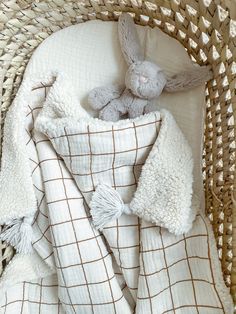 a basket with a blanket and stuffed animal in it