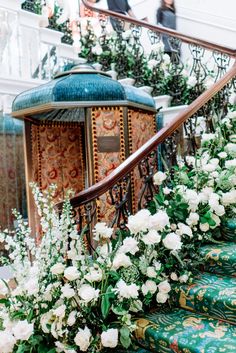 white flowers and greenery are on the stairs