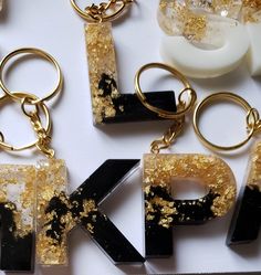 This handmade keychain is crafted with epoxy resin and gold foil flakes, creating a glamorous yet durable accent. Each letter is 1.5” tall and comes with gold hardware, with options for silver or rose gold. Each keychain is unique and custom-made, with small air bubbles and other slight imperfections possible. Shop our selection to find your favorite! hesitate to reach out. We have other keychain colors and designs available in the shop check them out to find your favorite! All keychains are make upon ordering take 3 days to make S Letter Resin Keychain, Epoxy Letter Keychains, Letter Keychain Resin, Letter Resin Keychain, Resin Letter Keychain, Diy Resin Keychain, Keychain Resin, Gold Keychain, Keychain Black