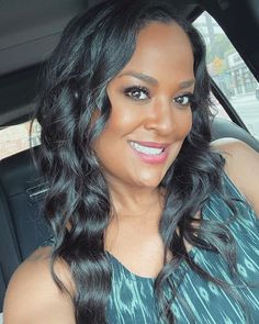 a woman is sitting in the back seat of a car and smiling at the camera