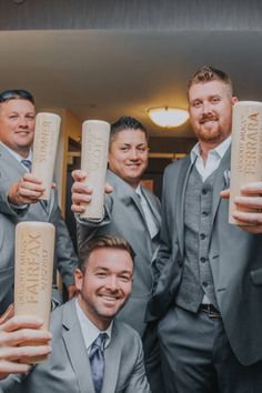 a group of men in suits and ties holding up two large tubes with words on them