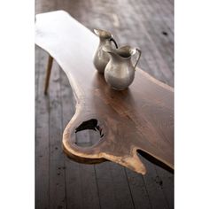 a wooden table with two vases sitting on it's top and one is made out of wood