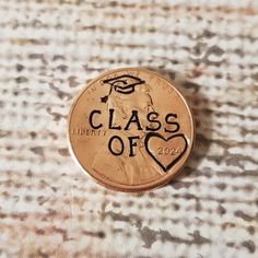 a penny with the words class of 20 on it is laying on a tablecloth