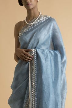 Editor's NoteThis set features a powder blue saree handwoven with linen and silk yarns. This piece is glorified by pearl white shells along the delicate light golden border. This saree comes with a matching blouse piece. Fabric: Linen Silk Sleeve Type: Strap Dimension: Length: 5.5m; Width: 1.1m Components: Saree and unstitched blouse piece Care: Dry Clean Only Customize Your OutfitCan't find the size you're looking for? No stress. Just select size "Custom" while adding the item to your cart. We Light Blue Wedding Saree, Blue Saree With White Blouse, White And Blue Saree, Blue And White Saree, Light Blue Silk Saree, Pastel Blue Saree, Powder Blue Saree, Light Saree, Light Blue Saree