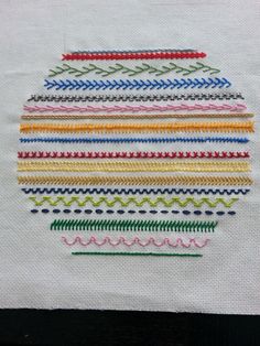 a close up of a piece of cloth with different colored stitchs on the side