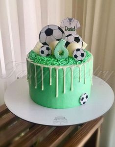 a soccer themed birthday cake with green icing and white frosting dripping down the side