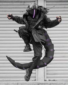 a man is jumping in the air while wearing a helmet and black pants with purple piping