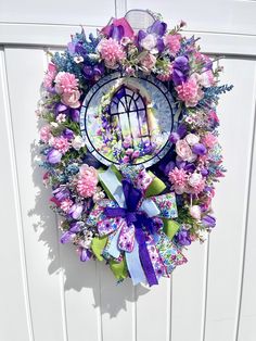 a wreath on the side of a door decorated with flowers and a birdcage