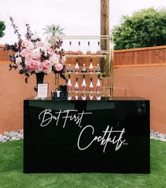 a black and white bar cart with pink flowers on the top that says, but first coffets