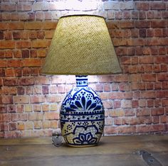 a blue and white vase sitting on top of a wooden table next to a lamp