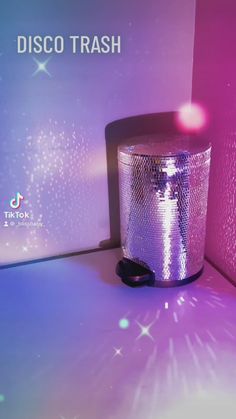 a disco trash can sitting on top of a purple and blue floor next to a wall