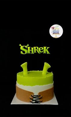 there is a cake with the name shrek on it and two knives sticking out of it