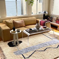 a living room filled with furniture and a large rug on top of a wooden floor