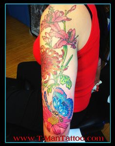 a woman's arm with flowers and butterflies on the back of her arm,