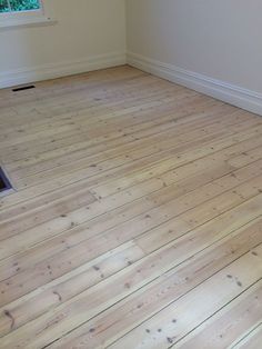 an empty room with hard wood flooring and a window