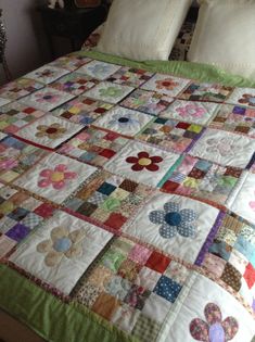 a quilted bedspread with flowers and hearts on it