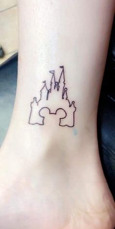 a small tattoo on the ankle of a woman's foot with two puzzle pieces