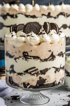 an oreo cookie trifle is shown in a glass dish on a table with cookies and marshmallows