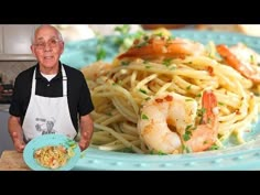 an old man standing in front of a plate of pasta and shrimp