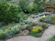 a gazebo in the middle of a garden filled with flowers