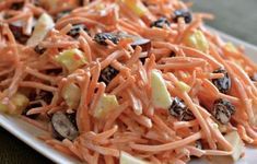 carrot salad with raisins and apples on a white plate