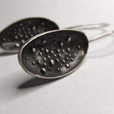 These wonderful earrings made in sterling silver have a modern contemporary design and a satin-matte finish. ► DESCRIPTIONS and MEASUREMENTS: Handmade from 925 sterling silver. This is a cast jewelry The earrings have a free oval shape with granulations (dots) on the inside of the oval. The ear wires are hammered at the front for more elegance. I gave the earrings a dark patina and then polished the top of the dots to emphasize the design. Oval shape size: 2.7 x 1.4 cm Earrings total height: 5.3 Contemporary Earrings With Oxidized Finish, Contemporary Earrings With Oxidized Finish As Gift, Contemporary Sterling Silver Earrings With Oxidized Finish, Contemporary Oxidized Finish Earrings For Gift, Contemporary Oxidized Finish Earrings, Contemporary Silver Drop Earrings, Oval Silver Earrings With Oxidized Finish, Contemporary Silver Earrings With Oxidized Finish, Contemporary Teardrop Sterling Silver Earrings