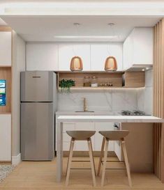 a small kitchen with two stools in front of the counter and refrigerator freezer