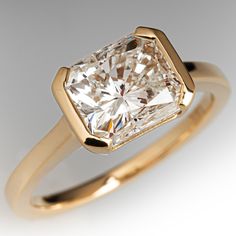 a yellow gold ring with a princess cut diamond