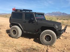 a black jeep is parked in the desert