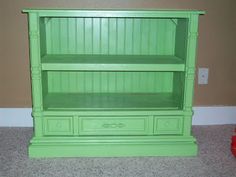 a green bookcase sitting on top of a carpeted floor next to a red fire hydrant