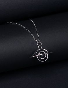 Featuring a black hole, this exquisite necklace is designed to honor Andrea Ghez, who was awarded the 2020 Nobel Prize in Physics for discovering the supermassive black hole that lurks at the center of the Milky Way. A Black hole is a great amount of matter packed into a very small area - think of a star ten times more massive than the Sun squeezed into a sphere approximately the diameter of New York City. The result is a gravitational field so strong that nothing, not even light, can escape. Th Physics Jewelry, Astronomy Necklace, Character Jewelry, Supermassive Black Hole, Nobel Prize In Physics, Space Necklace, Astronomy Gift, Fancy Rings, Shirt Design Inspiration