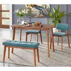 a wooden table with two chairs and a bench in front of it on a rug