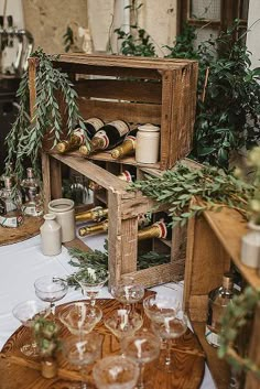 a wooden crate filled with wine glasses on top of a table