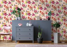 a living room with flowers on the wall and a grey dresser in front of it