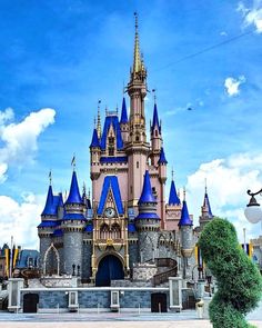 a large castle with many turrets and blue spires is shown in front of a cloudy sky