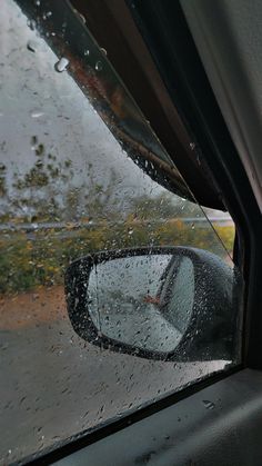 the side view mirror of a car on a rainy day