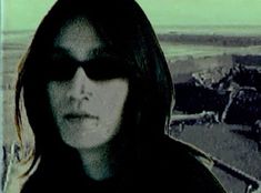 a woman with sunglasses is staring at the camera