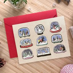 a christmas card with snow globes on it and pine cones in the corner next to it