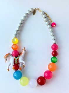 a necklace with beads and a horse on it