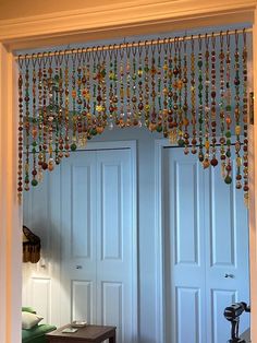 an open door with beads hanging from it's side and a table in front