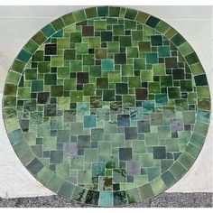 a green mosaic tile design on the side of a building