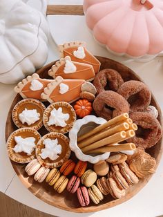 a wooden platter filled with lots of different types of cookies and pastries on top of a table