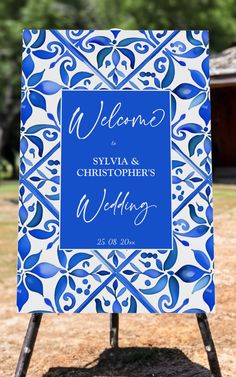 a blue and white welcome sign sitting on top of a wooden stand