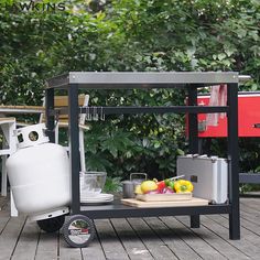 an outdoor bbq with drinks, lemons and water on the table next to it