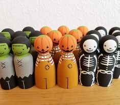 a group of halloween dolls sitting on top of a wooden table next to each other