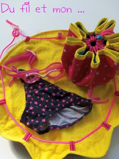 a pair of swimsuits sitting on top of a yellow towel