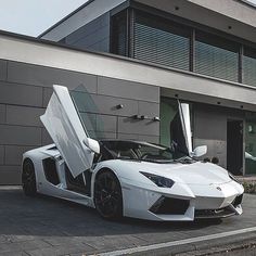 a white sports car parked in front of a building