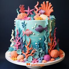 a blue cake decorated with sea creatures and seashells