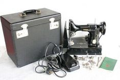 an old sewing machine and other items are sitting on the floor next to a briefcase