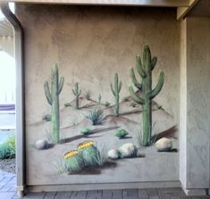 a mural on the side of a building with cactus and cacti painted on it